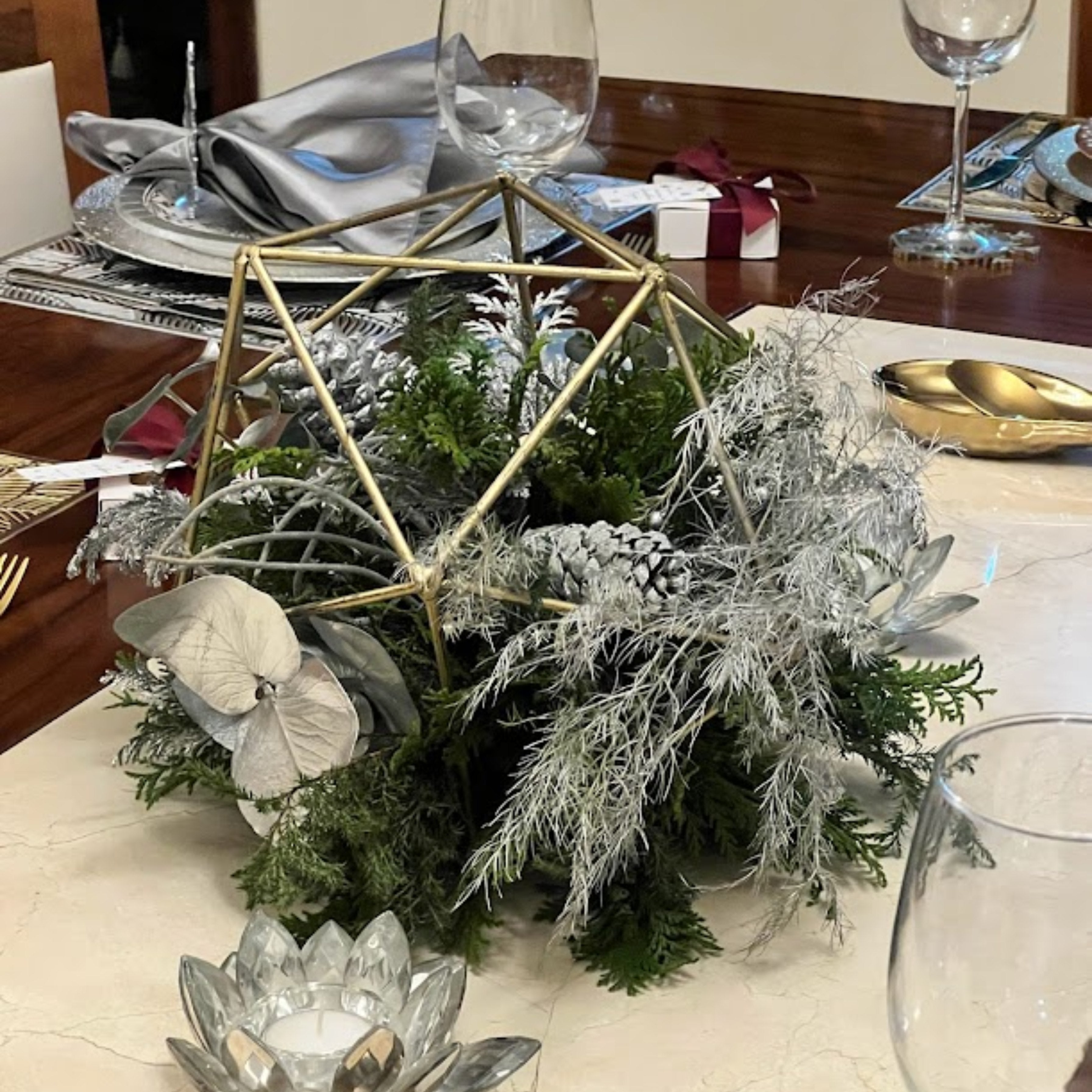 Centro de Mesa Navideño con Follaje Nevado, Piñas Blancas y Geometría Dorada | Semihita
